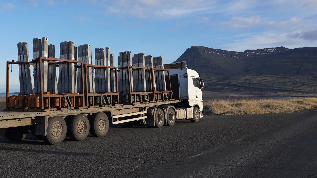 Vrachtwagen met oplegger vol stalen lading op een open weg